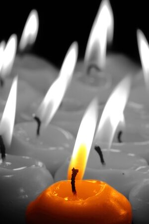 selective colour image of candles lit with flameの写真素材