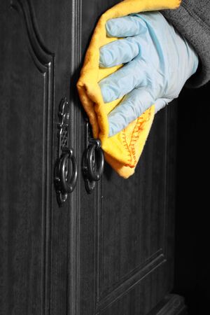 Abstract image of a man polishing a wooden sideboard with dusterの写真素材