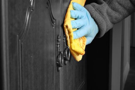 Abstract image of a man polishing a wooden sideboard with dusterの写真素材