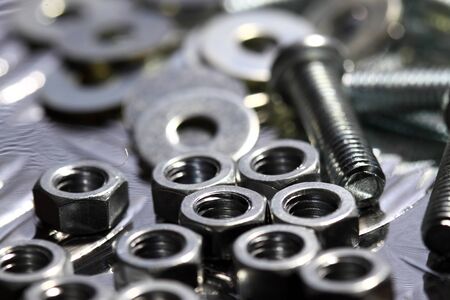 Nuts, bolts and washers on a steel backgroundの写真素材