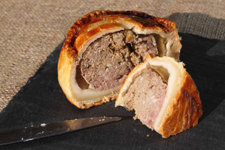 Pork pie sliced on a slate chopping boardの写真素材