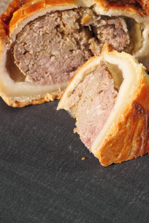 Pork pie sliced on a slate chopping board