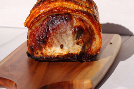Roast pork with crackling on a wooden chopping boardの写真素材