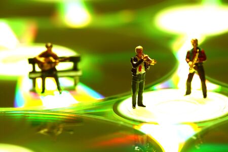 Miniature scale model musicians performing on a CD.の写真素材