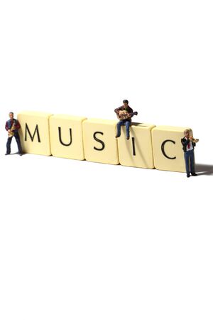 Miniature scale model musicians with tiles spelling musicの写真素材
