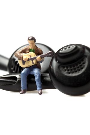 Miniature scale model guitarist on earphones.の写真素材