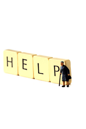 Miniature senior female pensioner on tiles spelling help