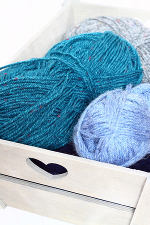 Balls of wool in a wooden crateの写真素材