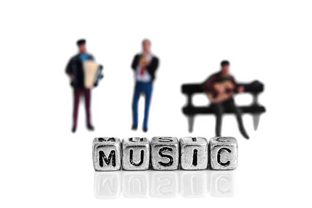 Miniature scale model musicians standing behind the word music on beadsの写真素材