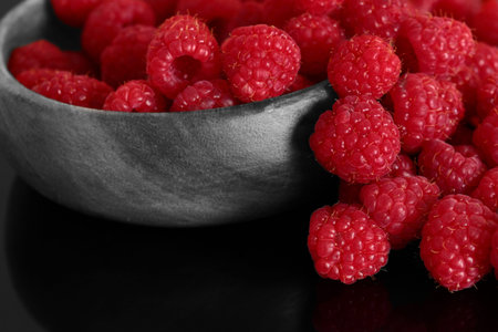 Raspberries in am wood bowl.  Selective colour