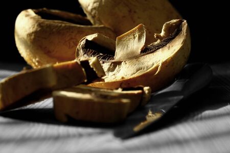 Sliced mushroom with knife on wood with selective colorの写真素材