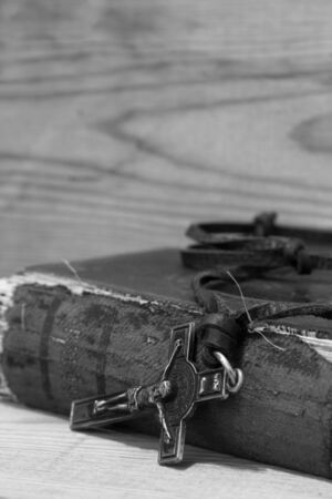 Crucifix necklace on a bible with wood background in black and whiteの写真素材