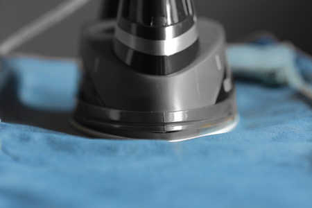 Electric iron on a pair of denim jeans with selective colorの写真素材