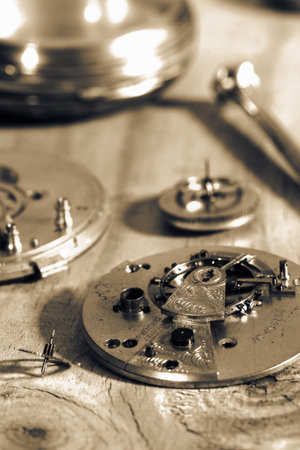 Parts and mechanism from an old antique pocket fob watch on a wood background