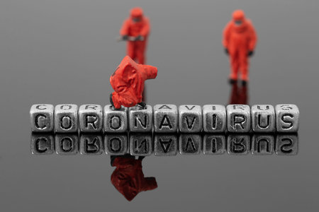 coronavirus on beads with miniature scale model chemical team reflected on a grey background