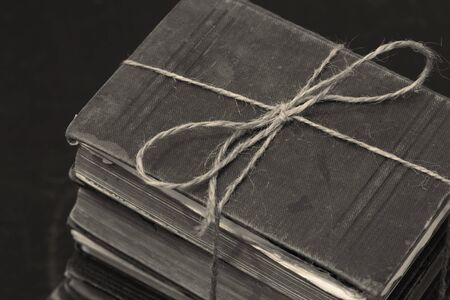 Antique old books stacked into a pile tied with string.  With colour toningの写真素材