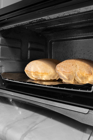 Loaves of bread cooked in an electric oven.  Selective colour image