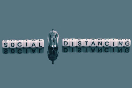 Miniature scale model man in a wheelchair, next to the words social distancing on beads.  Pandemic conceptの写真素材