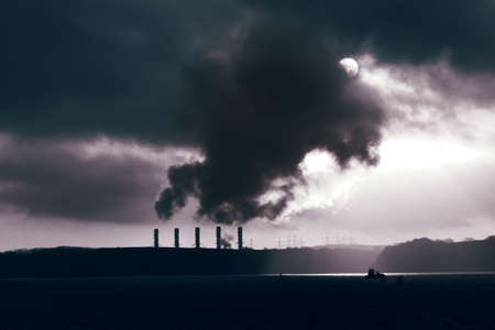 Power station on the coast at sunrise.  Global warming concept with colour toningの写真素材