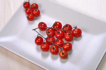 a bunch of cherry tomatoes, fresh and ready to be cut and seasoned with olive oil for a delicious Italian salad.の写真素材