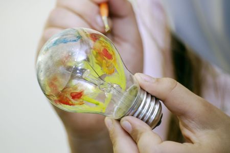 Multicolor painting light bulb in handの写真素材