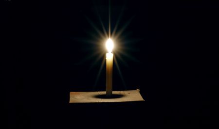 light candle on a black background in darkling の写真素材
