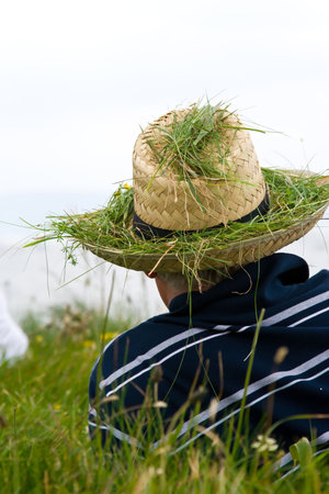 a man with a hat laid in a grass