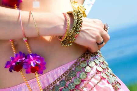 belly and a hand with bracelets and ringsの写真素材