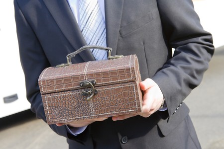 man in suit holding a leather trunk, detailsの写真素材