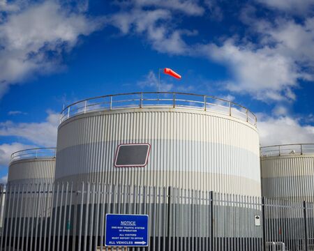 fuel tanks in industrial area and blue sky with cloudsの写真素材