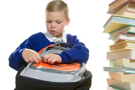 young boy in school uniform prepare his bag and heap of books の写真素材