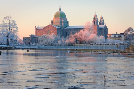 Galway Cathedral in First sunlights and Corrib river covered by ice at cold winter morningの写真素材