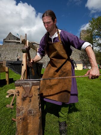 ATHENRY, IRELAND - AUGUST 21: Charlie Gallagher from Eireann Edge displays blacksmithing at annual National Walled Towns Day  on August 21, 2011 in Athenry, Ireland.のeditorial素材