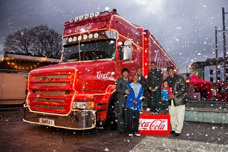 GALWAY - NOVEMBER 27: African family pose with Coca-Cola Christmas truck at "Holidays are coming" advert at Annual Galway Continental Christmas Market on November 27, 2011 in Galway, Ireland.のeditorial素材