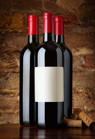 Bottles of red wine with corks and old brick wall backgroundの写真素材