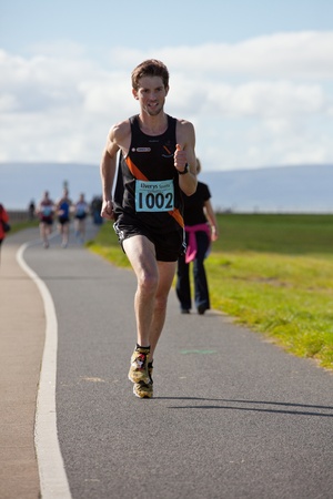 GALWAY, IRELAND - OCTOBER 6: Conor Healy (1002) and other athletes compete during annual Galway Bay Half Marathon and 10K, on October 6, 2012 in Galway, Ireland.のeditorial素材