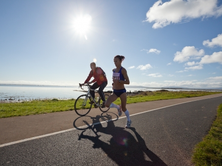 GALWAY, IRELAND - OCTOBER 6: Pauline Curley (3827), lead woman, escorted with race marshal, compete during annual Galway Bay Half Marathon and 10K, on October 6, 2012 in Galway, Ireland.のeditorial素材