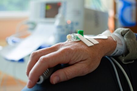 Close up of a patient hand with needle for intravenous dropper in hospital, shallow DOFの写真素材