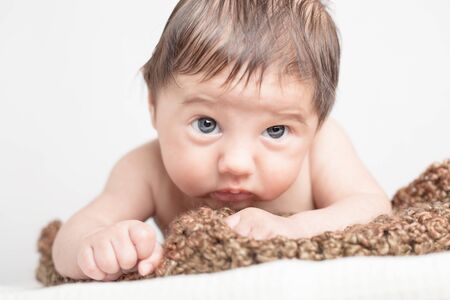 Cute baby boy lies on knitted blanketの写真素材