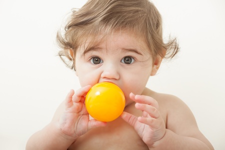Portrait of Cute baby boy playing with yellow ballの写真素材