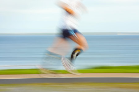Runner jogging by the ocean coast, blurred motion. People  are not recognizable