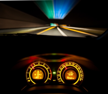 Driver view at speeding car  dashboard and motorway  at nightの写真素材