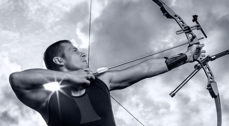 Tough man with bow and arrows, close up with cloudy sky at background  Monochromaticの写真素材