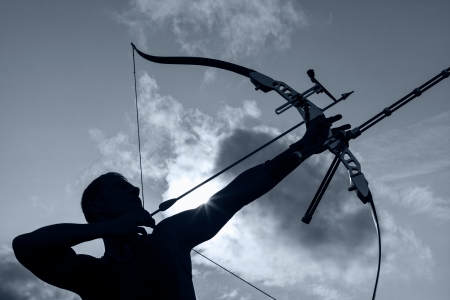 Tough man with bow and arrows, close up with cloudy sky at background  Monochromaticの写真素材
