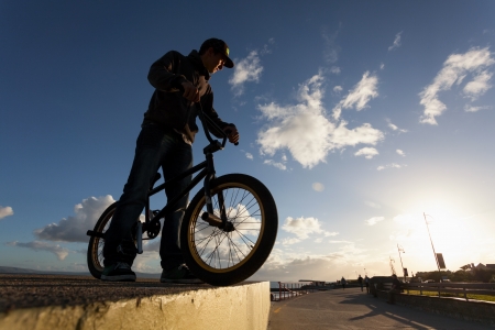 Young man with bicycle prepare to BMX stunts at the streetの写真素材