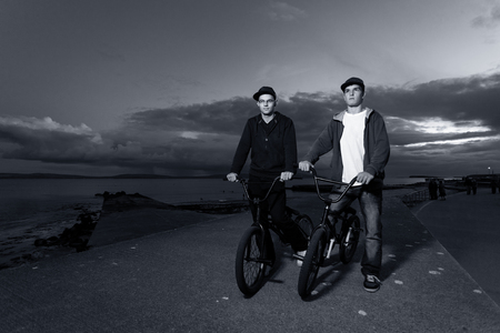 Two Young men with bicycles prepare to BMX stunts at the street  Monochromaticの写真素材
