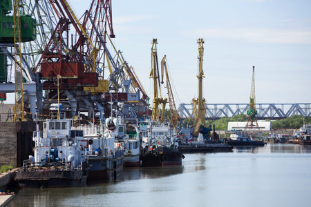 Industrial docks with ships and cranes on Irtish river, Omsk, Russia.