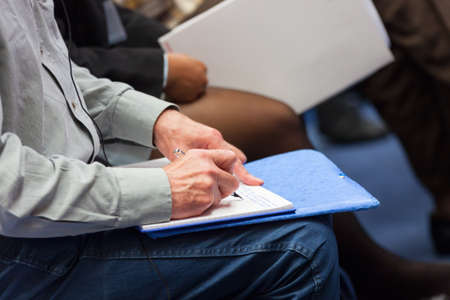 Close-up of Hands holding pens and making notes at the conferenceの写真素材