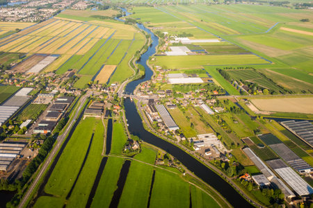 Aerial view over the Amsterdam suburbs with canals, houses , fields and industrial buildings....