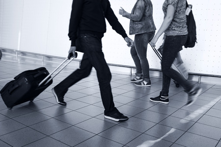 People with luggage walking at the airport. Details. Blurred motion.の写真素材